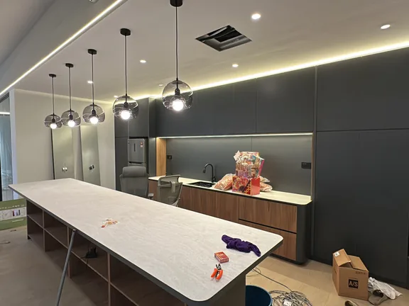 Completed office pantry with island counter and pendant lighting