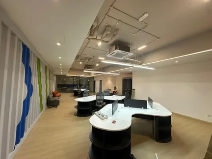Completed office workspace with curved workstations and linear feature lighting