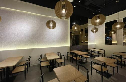 Completed restaurant dining area with timber tables and pendant lights