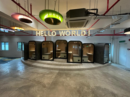 Completed commercial collaboration space with acoustic work pods and feature lighting